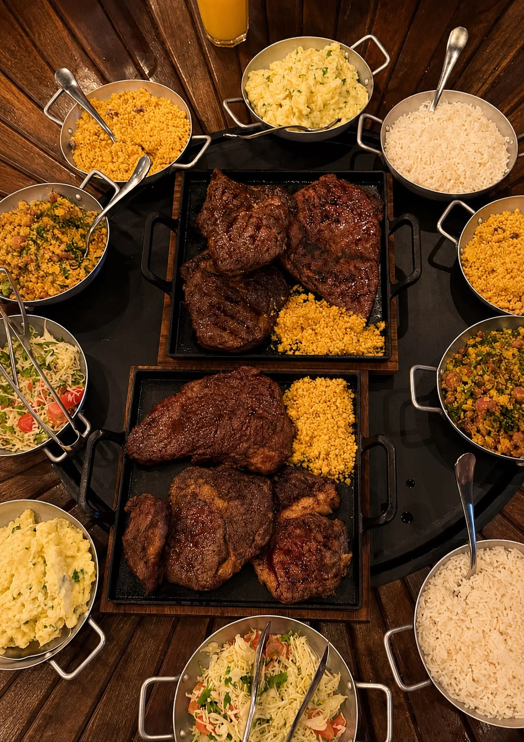 Mesa com carnes grelhadas e acompanhamentos